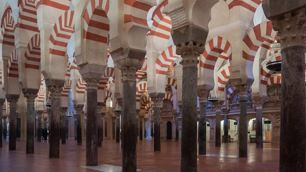 Forêt de colonnes et d'arcs en pierre rouge et blanche à l'intérieur de la mosquée-cathédrale de Cordoue