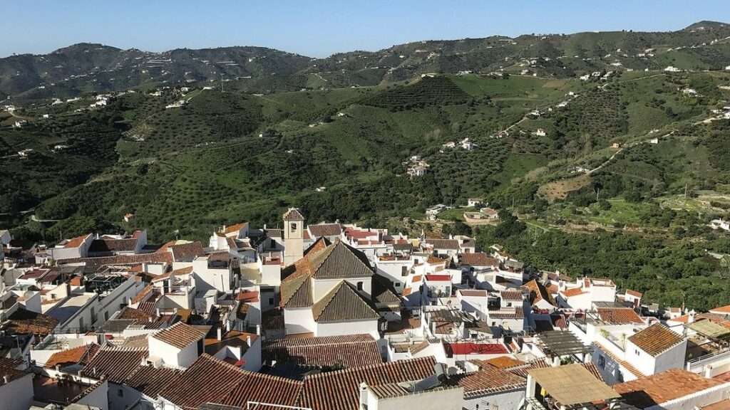 Maisons blanches et clocher de Frigiliana au pied de montagnes couvertes de végétation