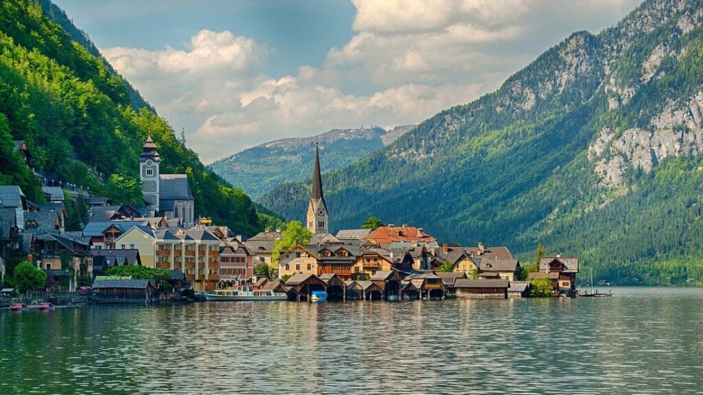 Maisons de Hallstatt au bord du lac, au pied de versants boisés et de montagnes rocheuses