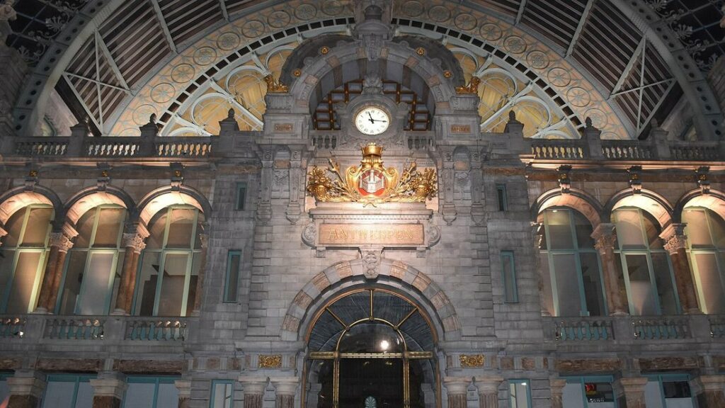 Grand hall de la gare d'Anvers-Central, avec ses arcades de pierre, son horloge et sa verrière