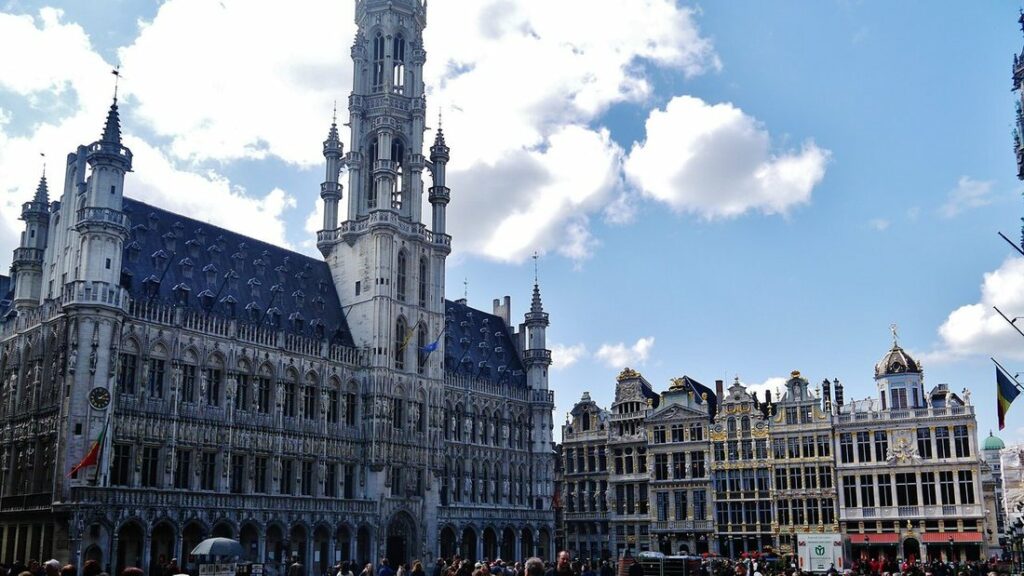 L'hôtel de ville gothique et sa haute flèche à gauche, à côté des maisons de corporations dorées de la Grand-Place