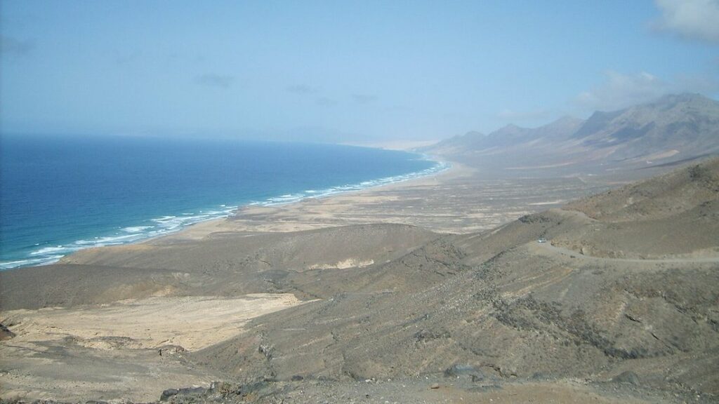 Longue plage de Cofete bordée par l'océan au pied des montagnes de Jandía, vue depuis les hauteurs