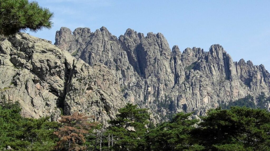 Crête rocheuse dentelée des aiguilles de Bavella, entre pins et ciel bleu