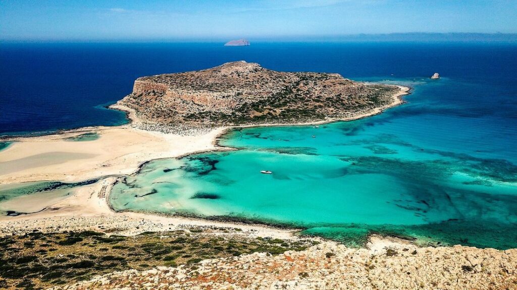Vue aérienne de la lagune de Balos, ses eaux turquoise, son banc de sable clair et la presqu'île rocheuse