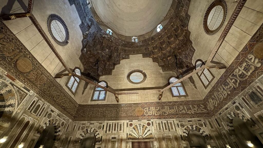 Dôme et plafond décoré à l'intérieur d'une mosquée du Caire, éclairé par des fenêtres rondes