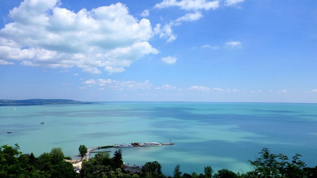 Eau turquoise du lac Balaton vue depuis une hauteur de Tihany, avec une rive lointaine sous un ciel bleu