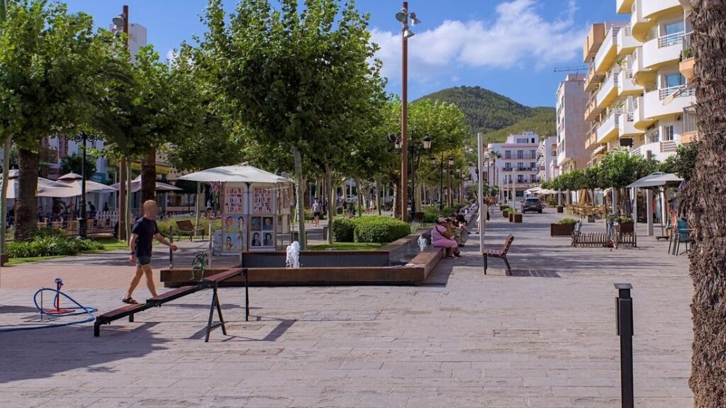 Promenade piétonne arborée de Santa Eulària des Riu, avec des terrasses et des immeubles en arrière-plan