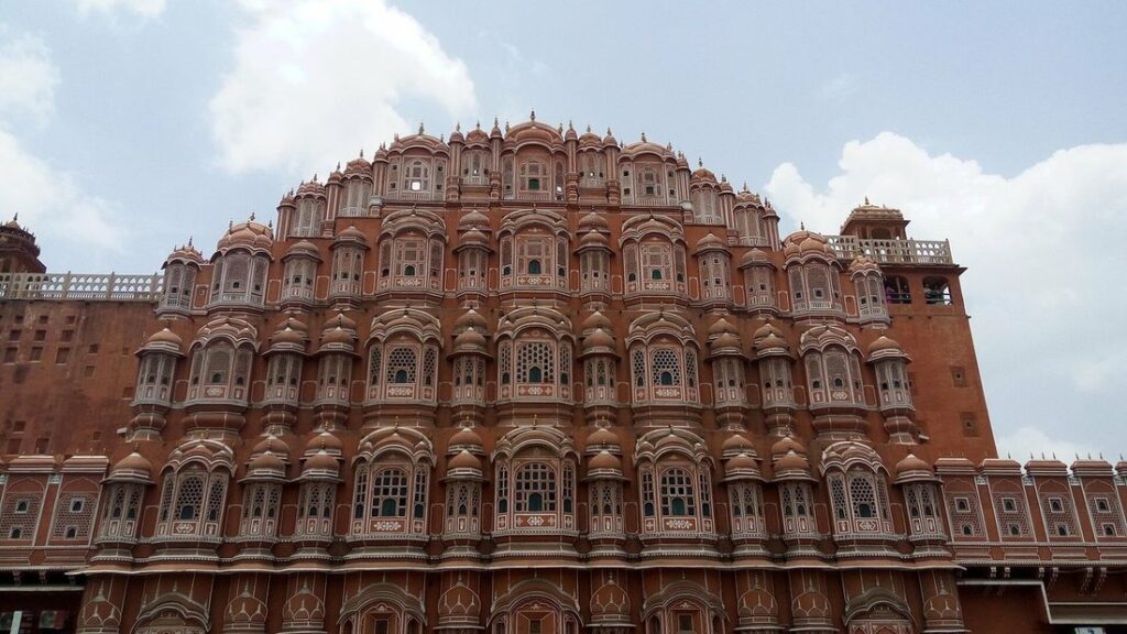 Façade en grès rose du Hawa Mahal à Jaipur, percée de nombreuses petites fenêtres