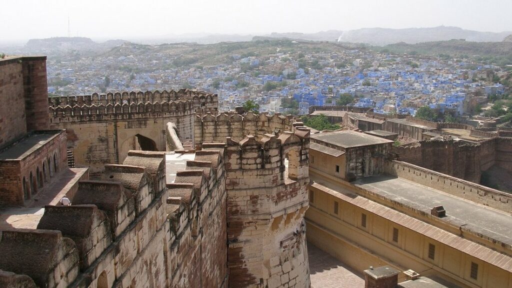 Remparts crénelés du fort de Mehrangarh, avec la ville de Jodhpur aux maisons bleues à l'arrière-plan