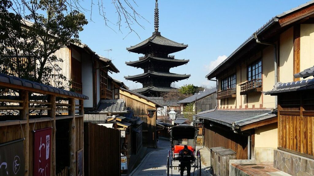 Pagode à cinq étages de Yasaka dominant une ruelle de maisons en bois de Higashiyama, avec un pousse-pousse