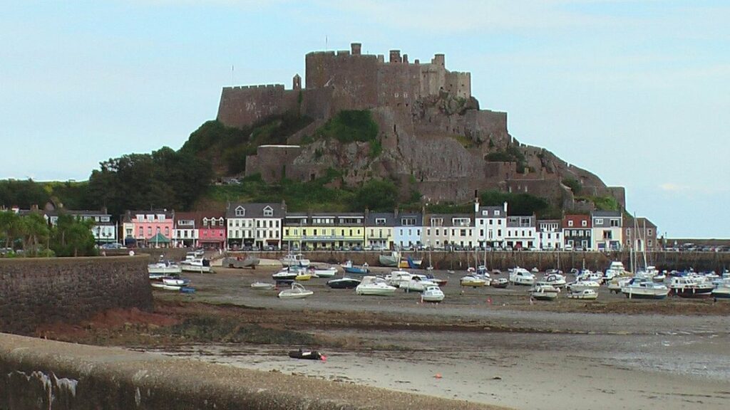 Château de Mont Orgueil dominant le port de Gorey et ses maisons colorées, à marée basse