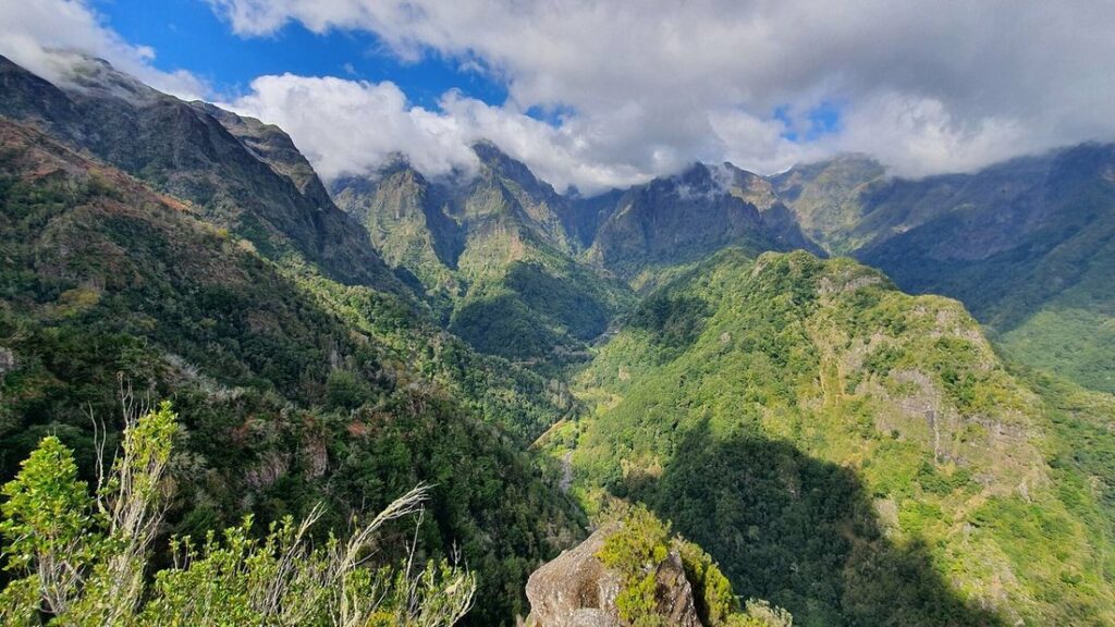 Vallée verte aux pentes boisées vue depuis un belvédère près de Ribeiro Frio, avec des nuages sur les crêtes