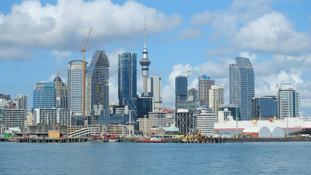 Gratte-ciel du centre d'Auckland, dont la Sky Tower, derrière l'eau du port sous un ciel nuageux