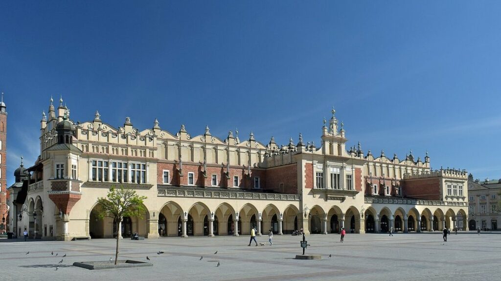 Halle aux draps Sukiennice sur la grande place du marché de Cracovie, avec ses arcades et la place pavée