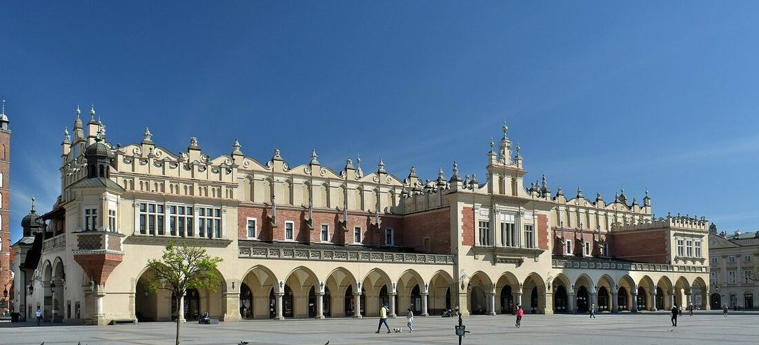Halle aux draps Sukiennice sur la grande place du marché de Cracovie, avec ses arcades et la place pavée