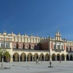 Halle aux draps Sukiennice sur la grande place du marché de Cracovie, avec ses arcades et la place pavée