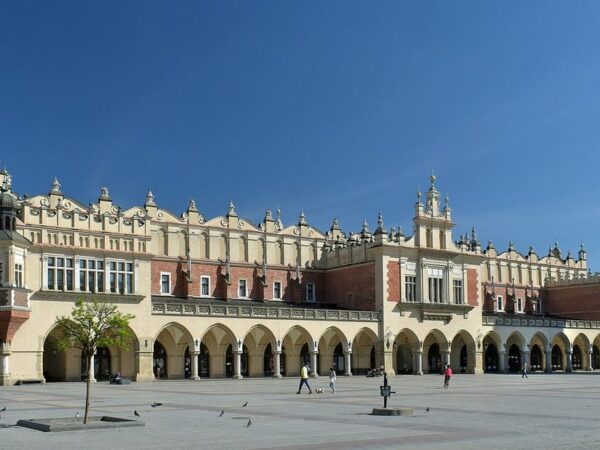 Halle aux draps Sukiennice sur la grande place du marché de Cracovie, avec ses arcades et la place pavée