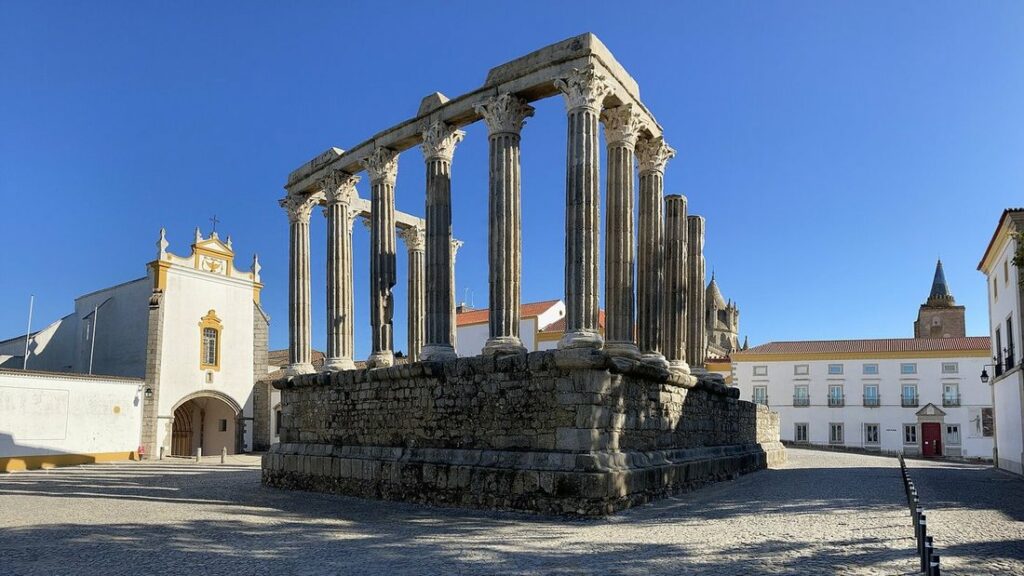 Temple romain d'Évora, colonnes de granit sur un podium de pierre, au bord d'une place pavée
