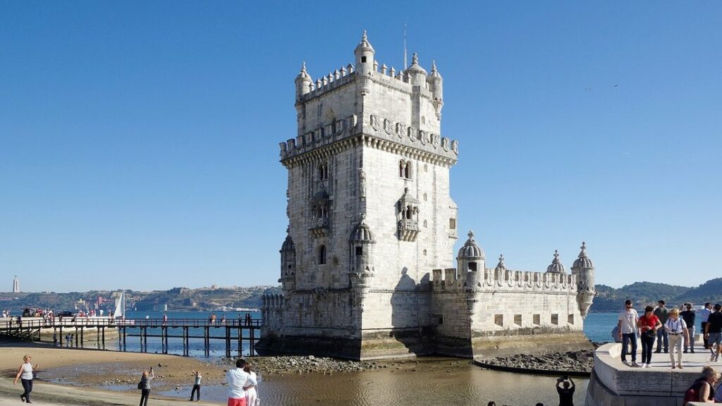 Tour de Belém, tour de pierre claire au bord du Tage, avec des promeneurs sur la berge