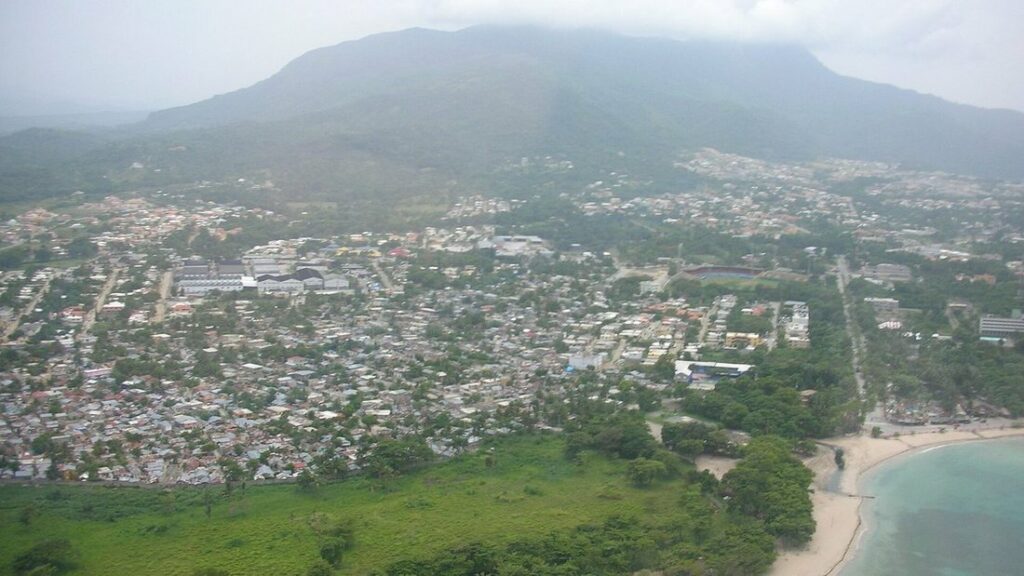 Vue aérienne d'une ville aux toits serrés, avec une grande montagne en arrière-plan dans la brume