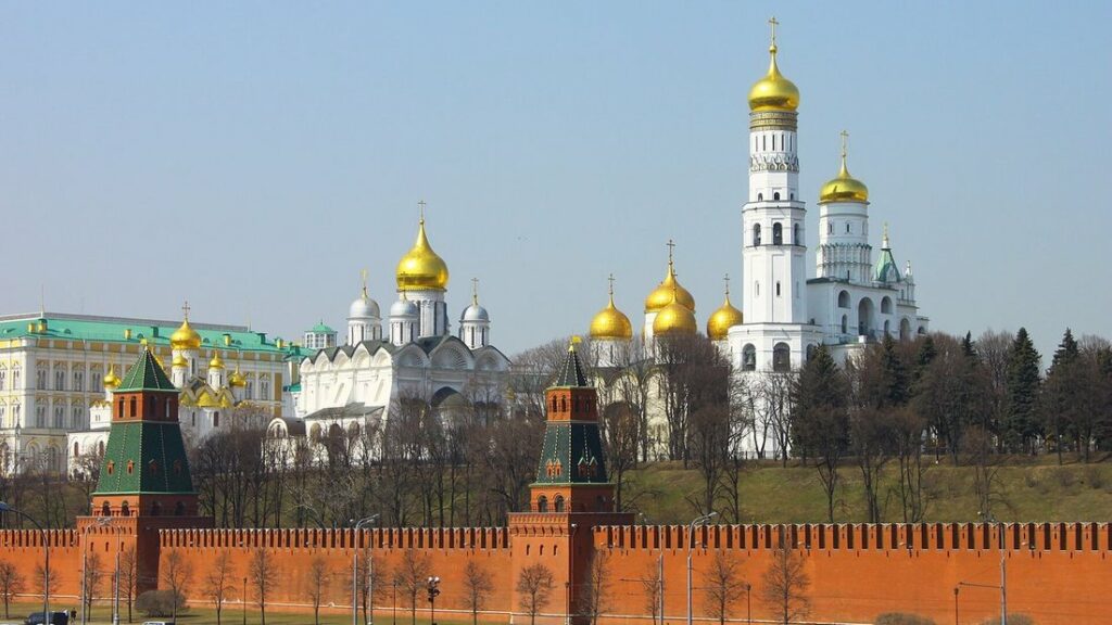 Murailles rouges du Kremlin de Moscou dominées par des clochers blancs et des coupoles dorées