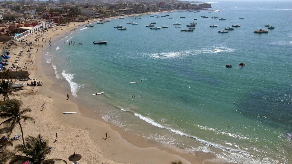 Baie de Ngor vue d'en haut, avec une plage de sable, des palmiers et des barques au mouillage