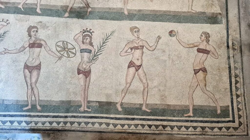 Mosaïque romaine au sol montrant plusieurs jeunes femmes en tenue de sport, tenant palmes et ballons