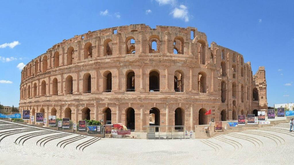 Façade en pierre à étages d'arcades de l'amphithéâtre romain d'El Djem, sous un ciel bleu