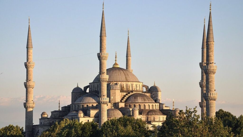 La mosquée du sultan Ahmed, ses dômes en cascade et ses minarets élancés, devant un ciel bleu pâle
