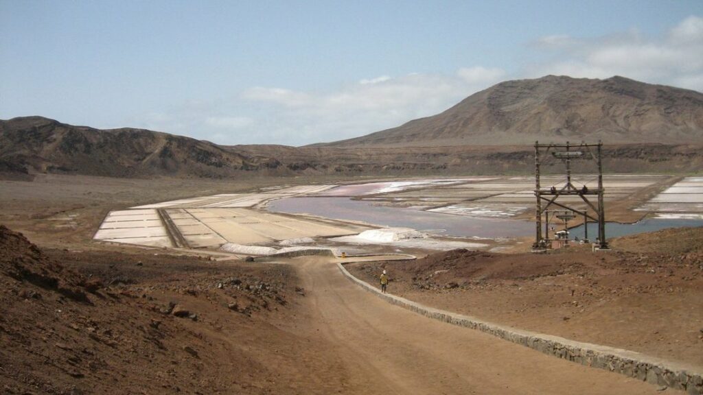 Salines de Pedra de Lume au fond d'un cratère volcanique, sous des montagnes arides, avec un pylône en bois