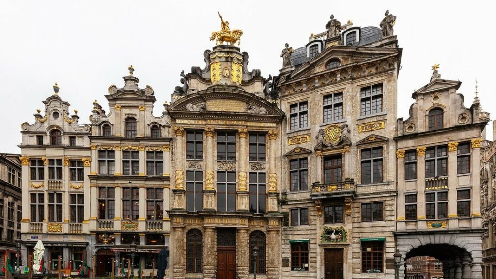 Façades dorées et sculptées de maisons de corporation sur la Grand-Place de Bruxelles, sous un ciel clair