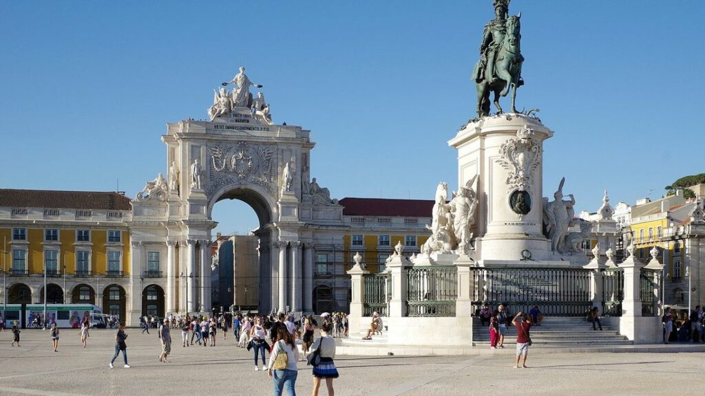 Arc de la rue Augusta et statue équestre au centre de la Praça do Comércio, entourés de bâtiments jaunes
