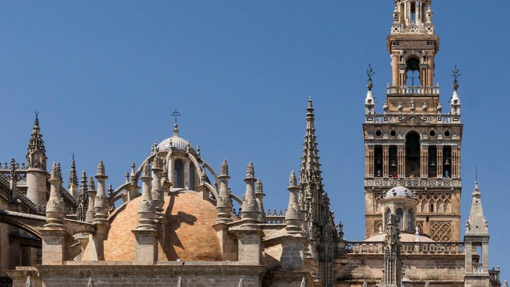 La Giralda, tour de la cathédrale de Séville, et les pinacles et la coupole de la cathédrale sous un ciel bleu