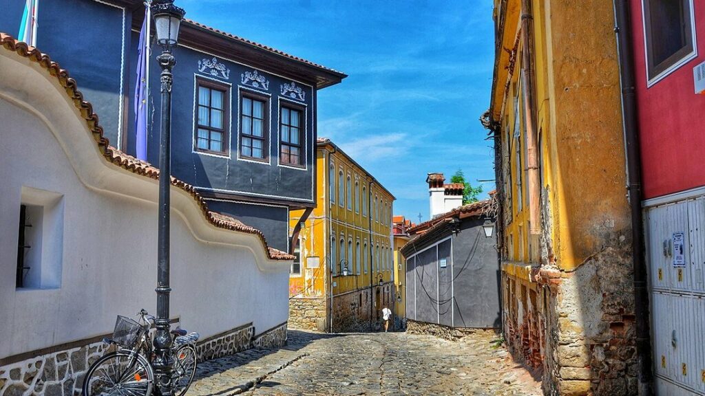 Ruelle pavée de la vieille ville de Plovdiv entre des maisons aux façades bleue, jaune et blanche