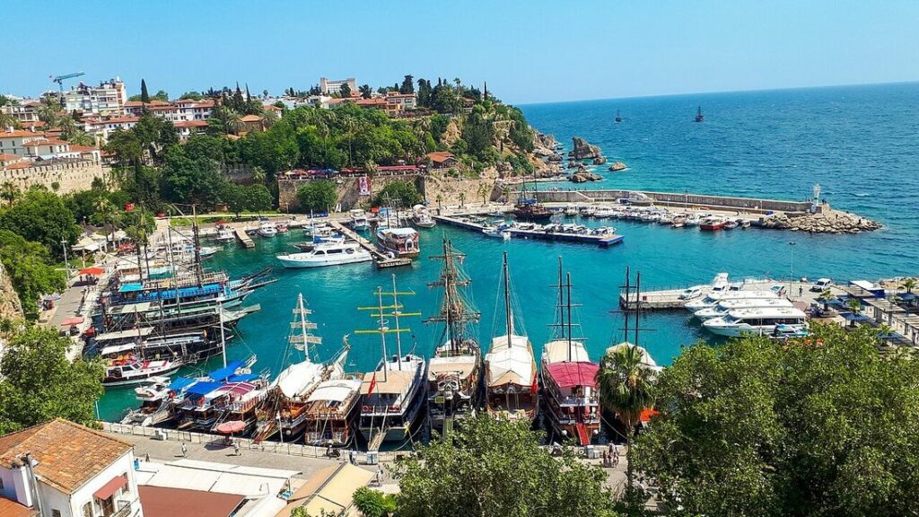 Vue plongeante sur l'ancien port d'Antalya, ses bateaux à voiles, sa marina et la falaise de la vieille ville