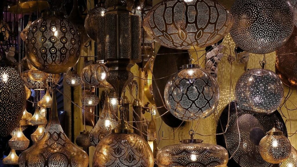 Lanternes métalliques ajourées suspendues en grappes dans un souk, éclairées de l'intérieur
