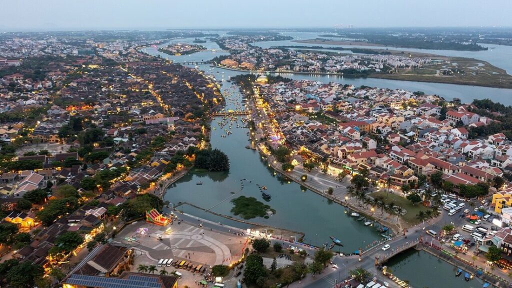 Vue aérienne de Hội An au crépuscule : toits de tuiles, rivière Thu Bồn et lumières de la vieille ville