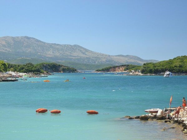 Baie turquoise de Ksamil, en Albanie, avec des îlots boisés et une chaîne de montagnes à l'horizon