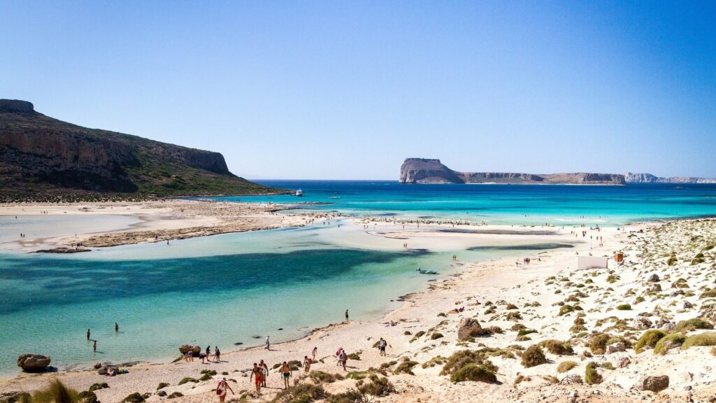 Lagune de Balos, en Crète, avec un banc de sable clair, une eau turquoise peu profonde et quelques baigneurs
