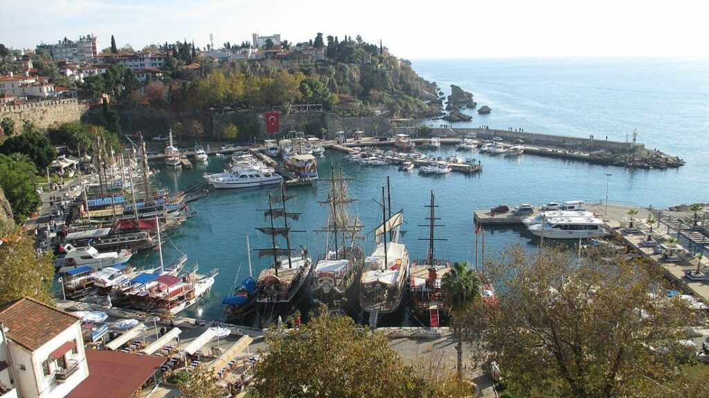 Port de plaisance d'Antalya vu d'en haut, avec voiliers à mâts et vieille ville aux toits rouges sur la colline