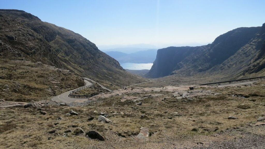 Route étroite en lacets descendant du col de Bealach na Bà vers un loch, entre deux versants rocheux