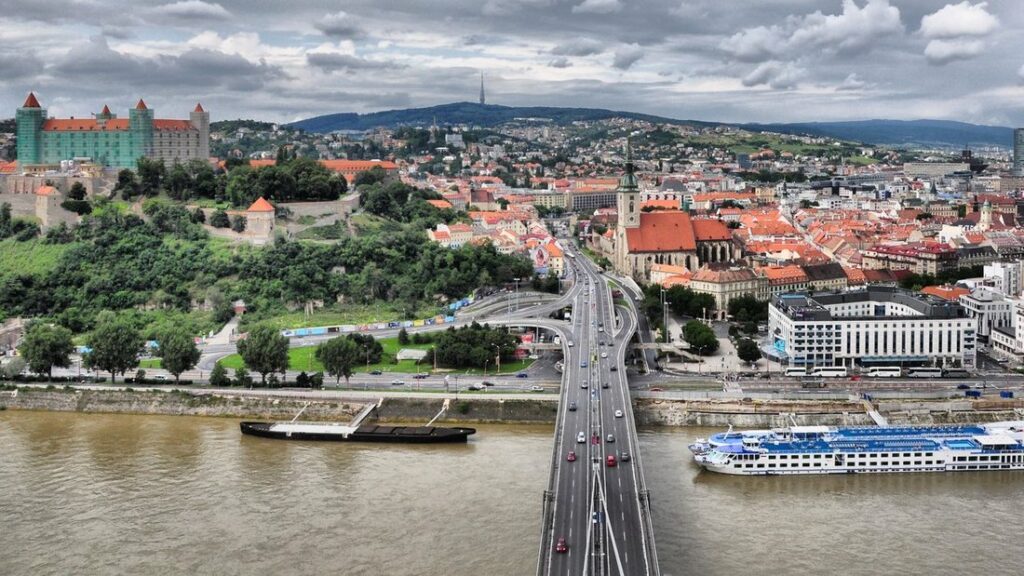 Bratislava vue d'un pont : le Danube, la vieille ville aux toits orangés et le château sur la colline
