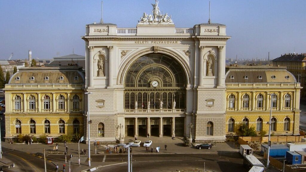 Façade de la gare Keleti de Budapest, avec sa grande verrière en arc, son horloge et ses statues au sommet