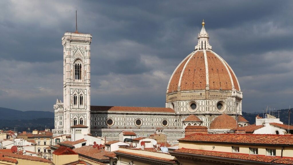 Le dôme de brique rouge de la cathédrale de Florence et le campanile de Giotto, sous un ciel sombre