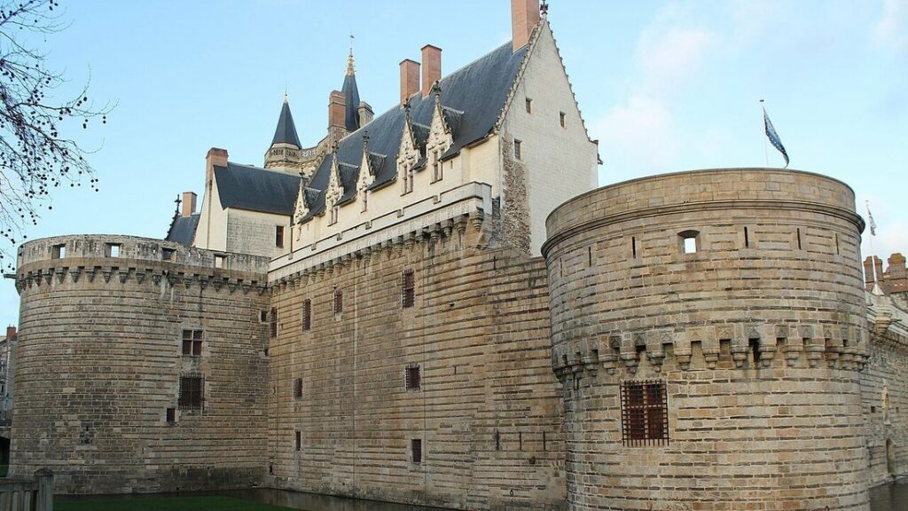 Tours rondes et remparts de pierre du château des ducs de Bretagne à Nantes, sous un ciel bleu clair