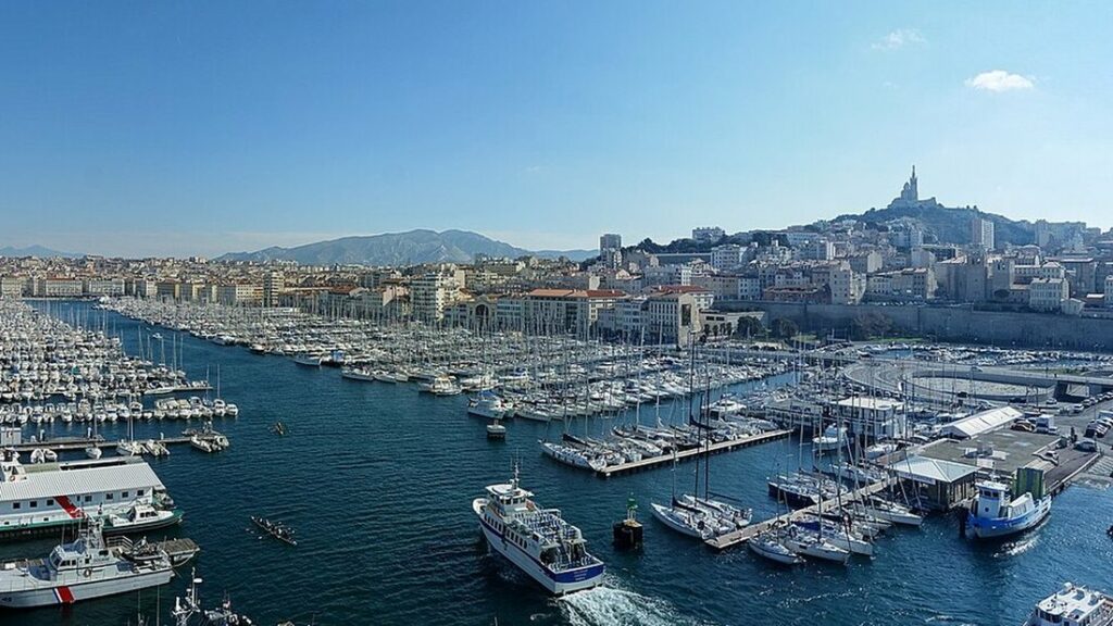 Vue d'en haut du Vieux-Port de Marseille, bateaux amarrés et basilique Notre-Dame de la Garde sur sa colline