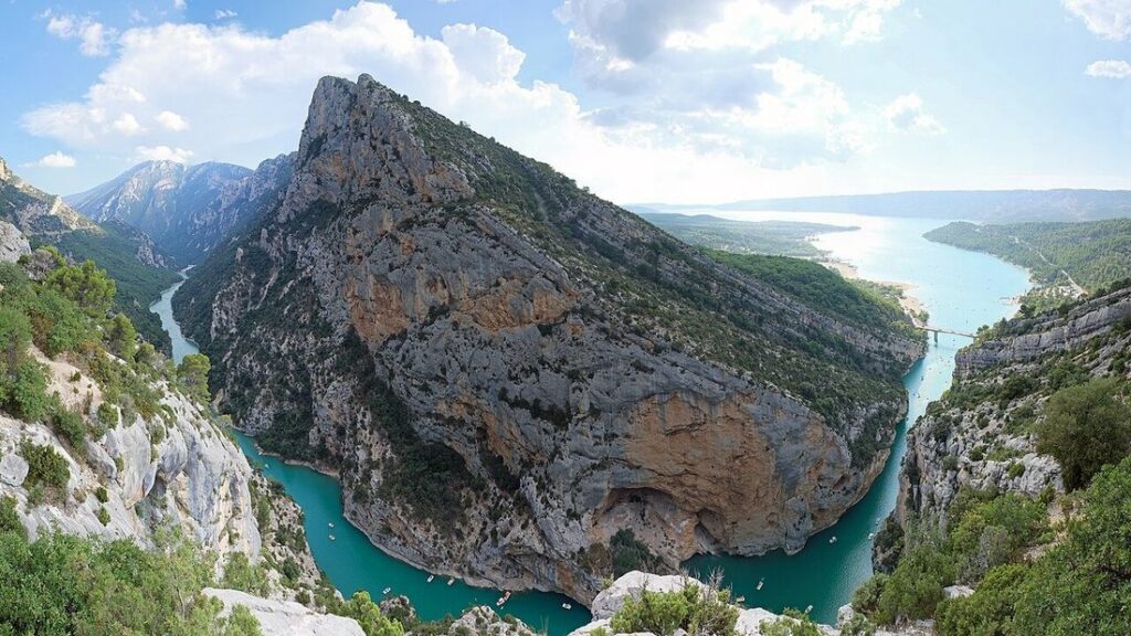 Gorges du Verdon vues d'en haut : rivière turquoise entre de hautes parois calcaires, lac lointain à droite