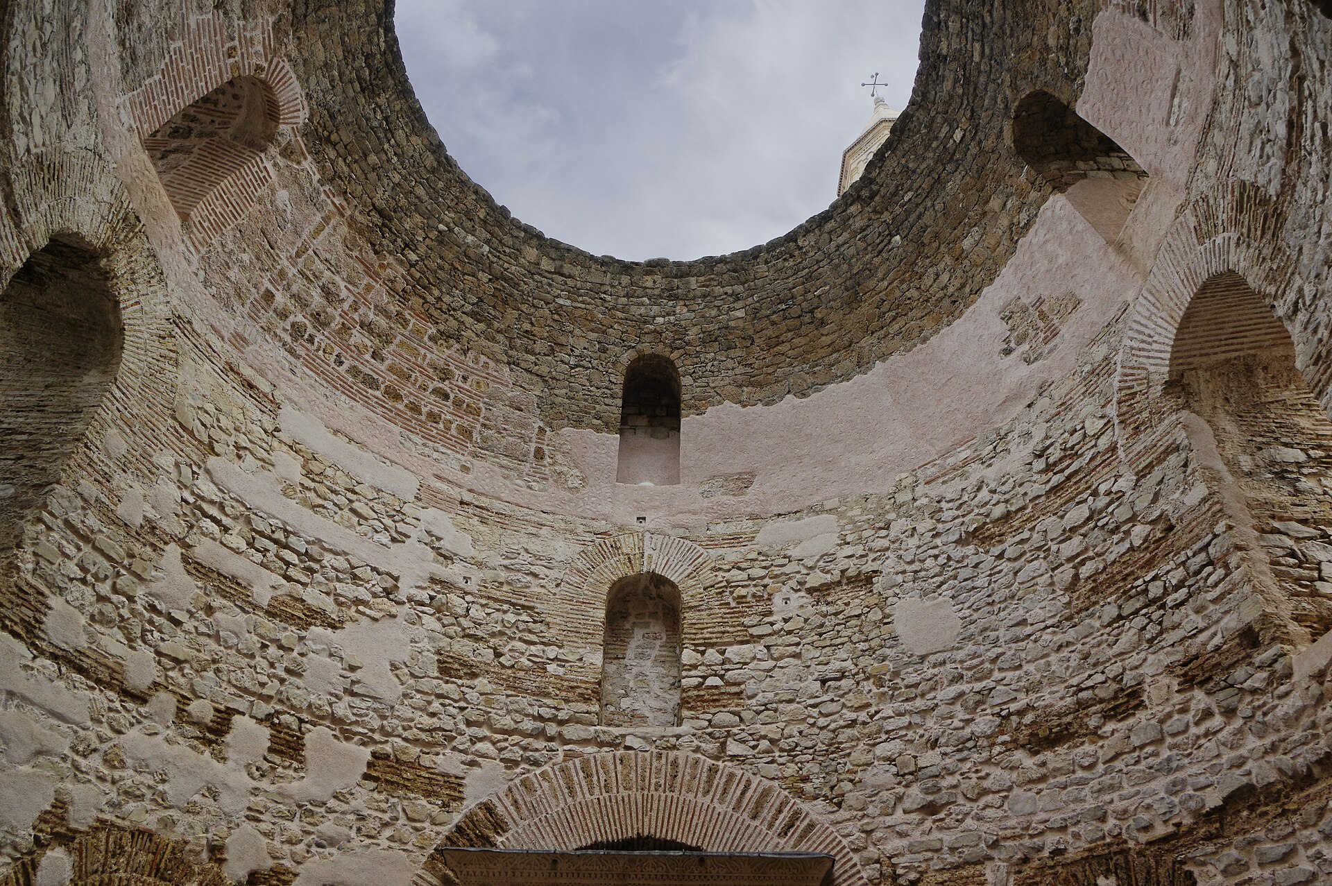 Vestibule du palais de Dioclétien à Split : salle circulaire en pierre et en briques ouverte sur le ciel, clocher à droite